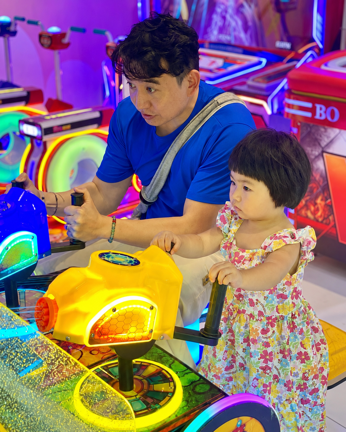 An adult and child enjoying an arcade game at MetaPark