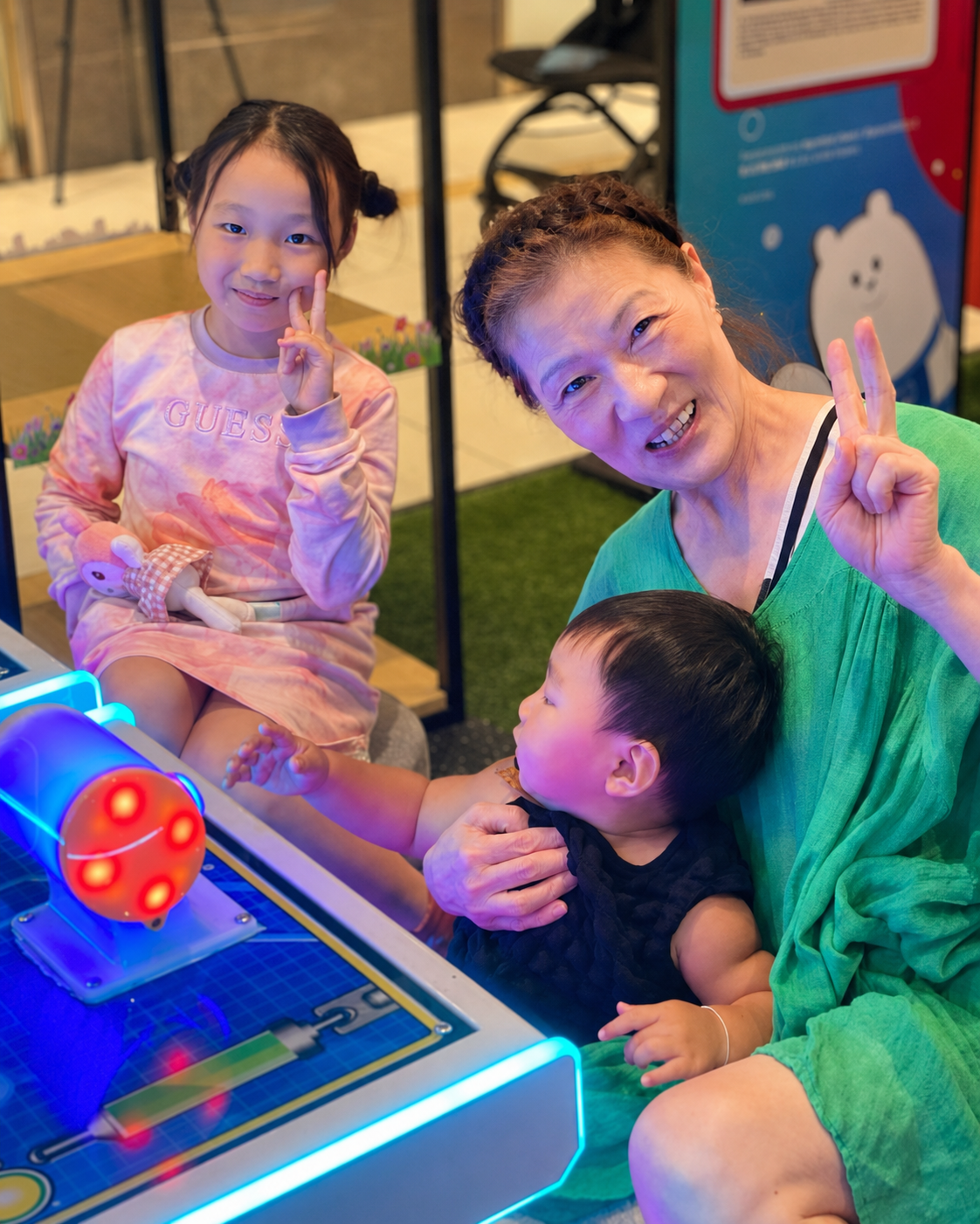 A grandmother and children enjoying an arcade game at MetaPark